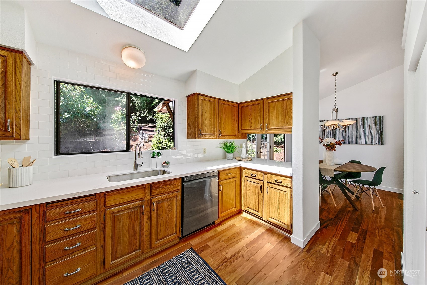 21822 4th Avenue Southeast Bothell, WA 98021 - Photo 7 of 40 a kitchen with stainless steel appliances granite countertop a stove a sink dishwasher and a refrigerator with wooden floor