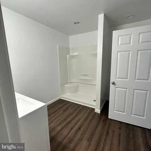 a view of an empty room with wooden floor