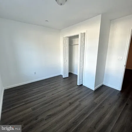 an empty room with wooden floor and closet