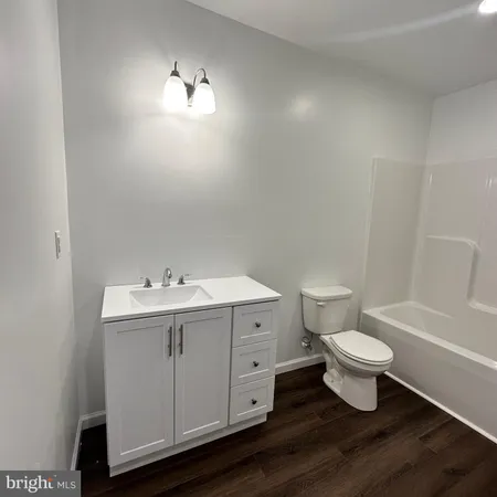 a bathroom with a white toilet sink a mirror and vanity