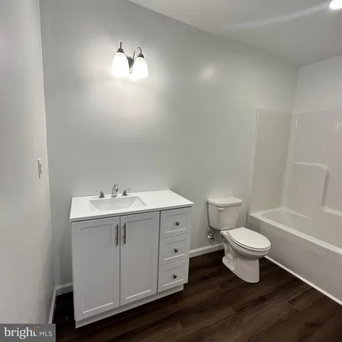 a bathroom with a white toilet sink a mirror and vanity