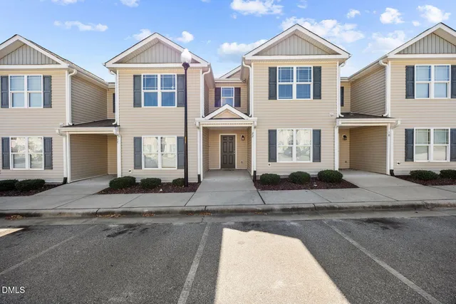 a front view of a house with yard and road