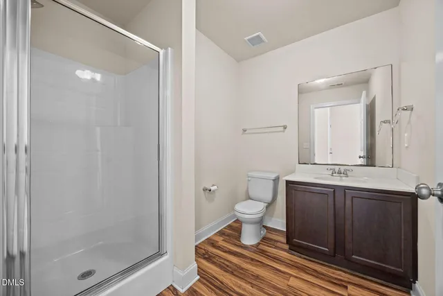 a bathroom with a sink toilet a mirror and shower
