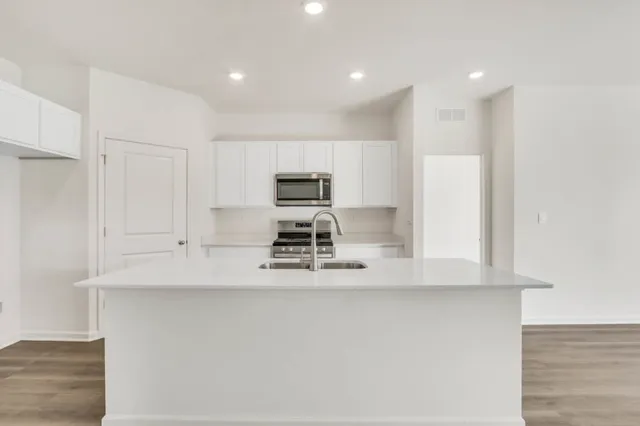 a kitchen with kitchen island white cabinets and stainless steel appliances
