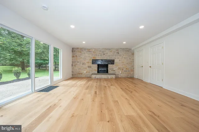 a view of empty room with wooden floor and fireplace