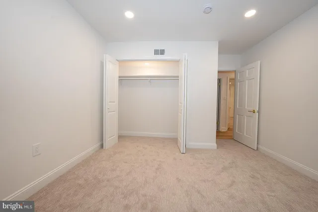 an empty room with closet and mirror
