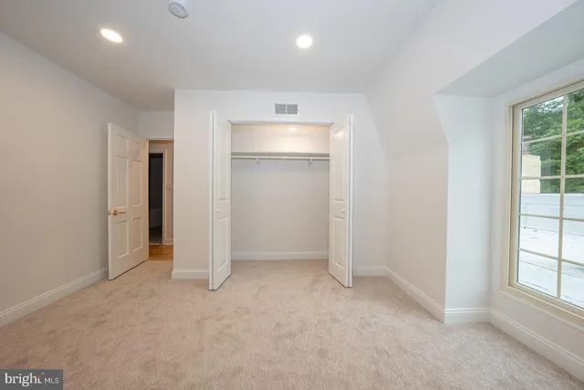 an empty room with windows and closet