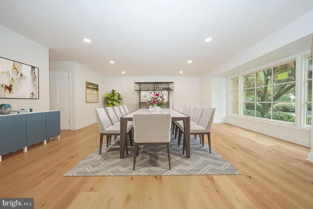 a view of a dining room with furniture a rug and wooden floor