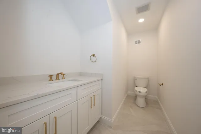 a bathroom with a granite countertop toilet and sink