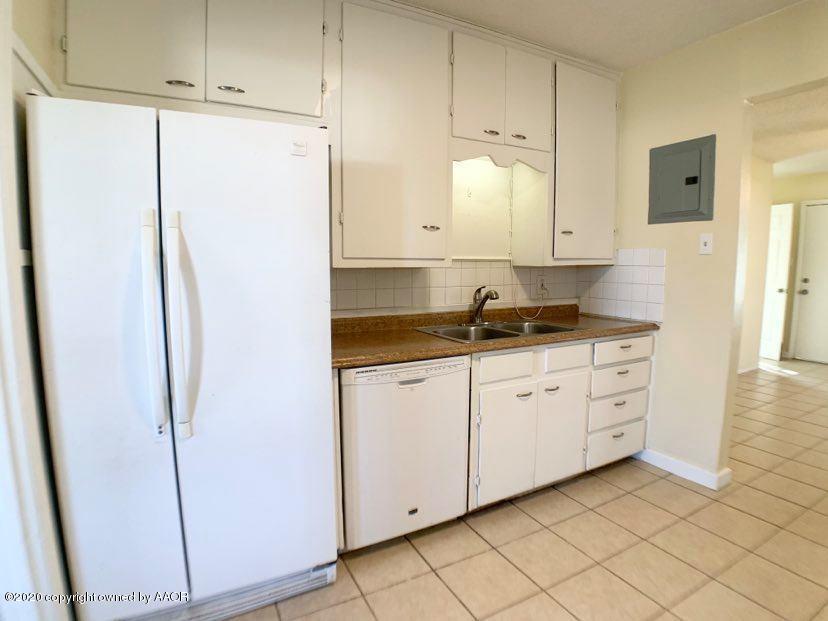 4124 South Jackson Street Amarillo, TX 79110 - Photo 3 of 13 a kitchen with a refrigerator and white cabinets
