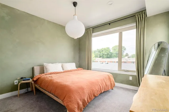 a bedroom with a large bed and a large window