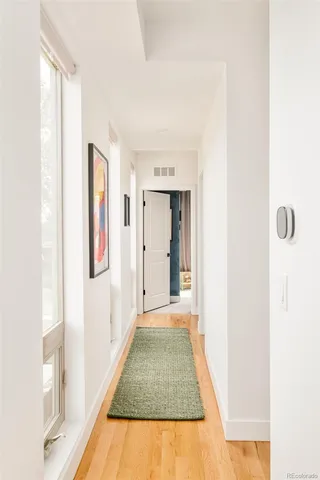 a view of a hallway with white walls and a window