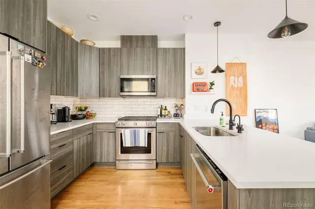 a kitchen with stainless steel appliances a sink stove and refrigerator