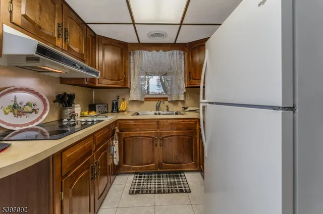 a kitchen with a refrigerator and a stove top oven
