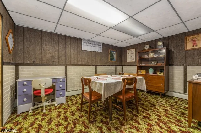 a living room with a couch and dresser next to a window