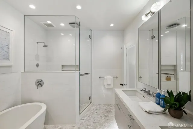 a bathroom with a tub sink shower and mirror