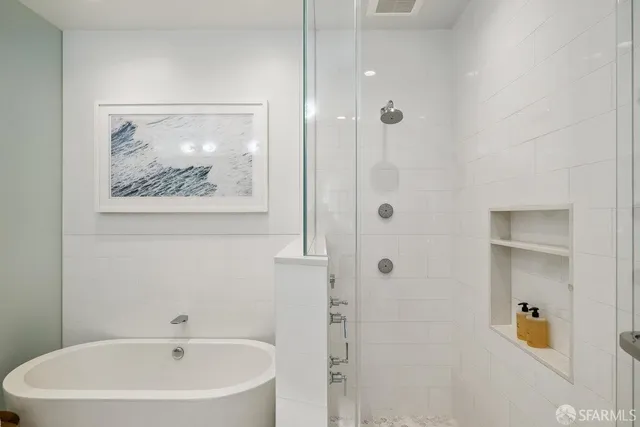 a white bath tub sitting next to a white sink and vanity