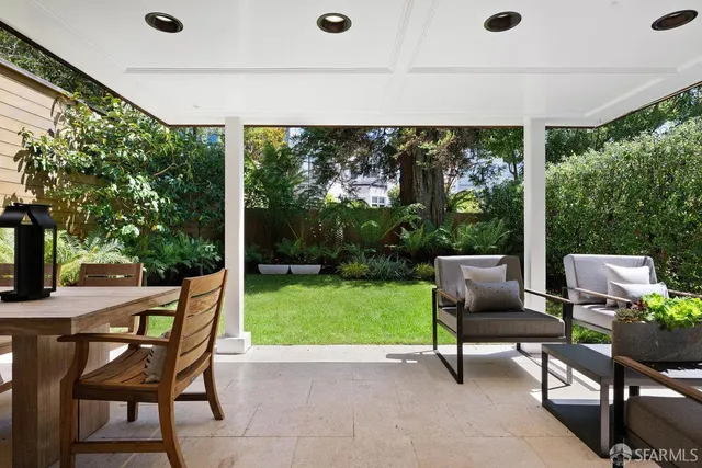 a view of a patio with a table chairs and a backyard