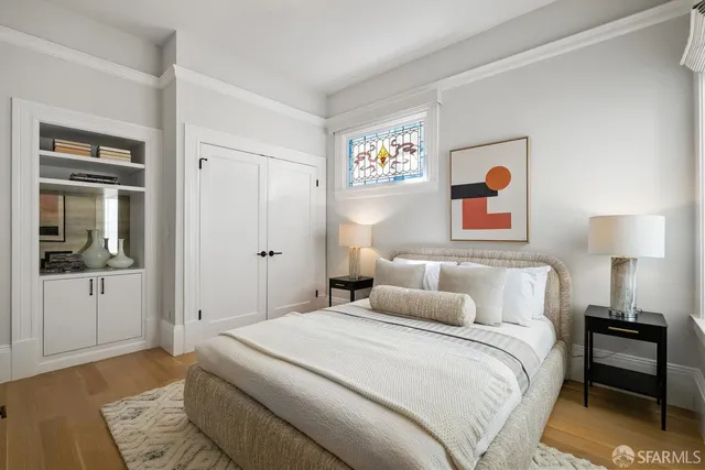 a bedroom with a bed and a lamp on dresser