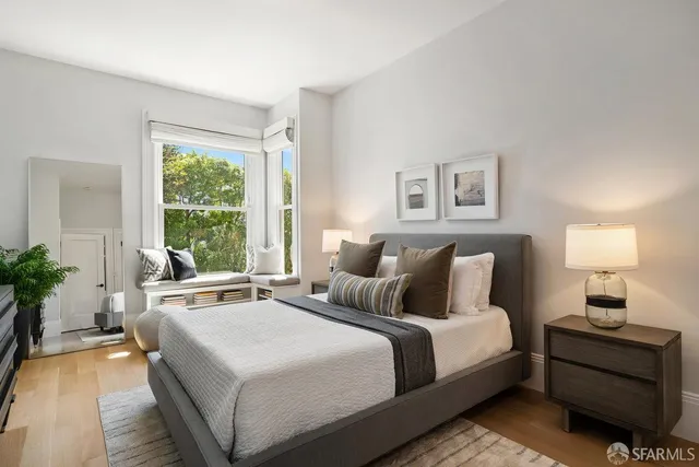 a bedroom with a large bed and a lamp on table