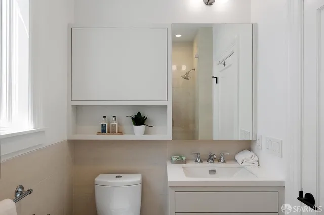 a bathroom with a sink a toilet and shower