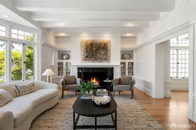 a living room with furniture a fireplace and wooden floor