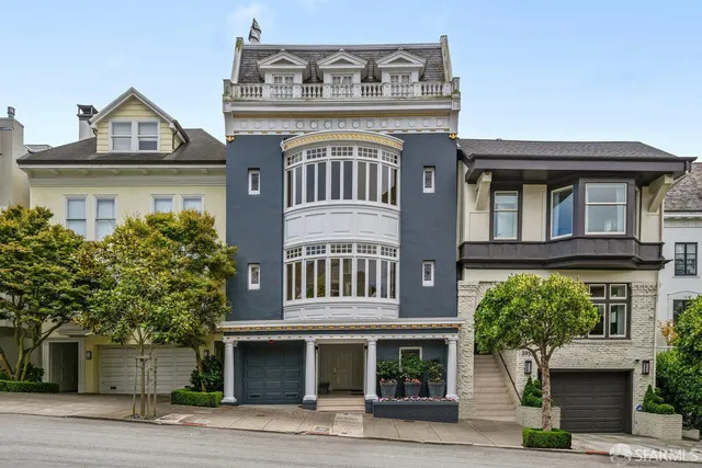 a front view of a residential apartment building with a yard and garage