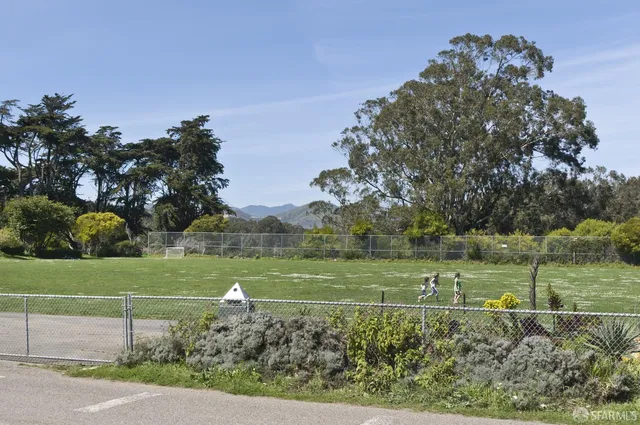 a view of a house with a big yard and large trees