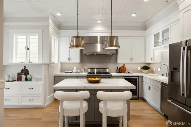 a kitchen with stainless steel appliances a stove a sink island and a refrigerator