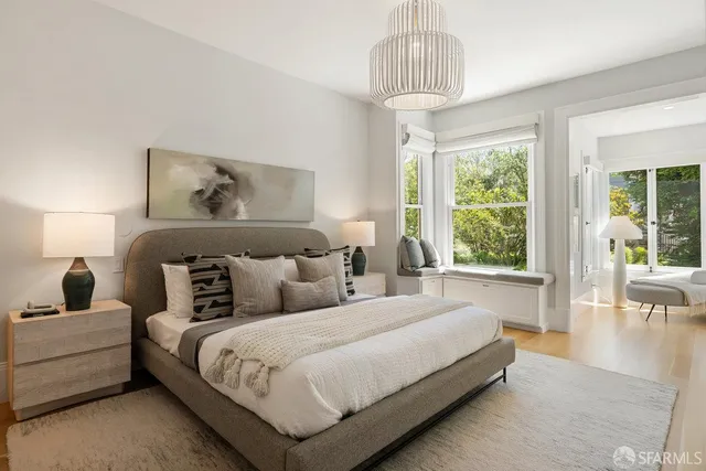 a spacious bedroom with a bed and a chandelier