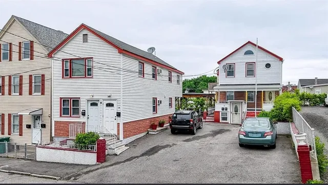 a view of house with a car parked beside it
