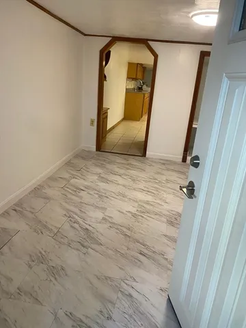 a view of a room with wooden floor and mirror