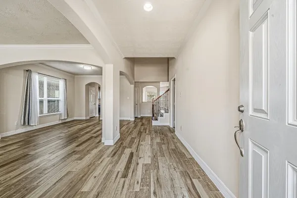 an empty room with wooden floor and windows