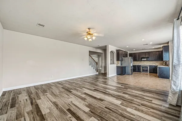 a view of a livingroom with wooden floor and stairs
