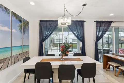 a kitchen with a dining table chairs and white cabinets