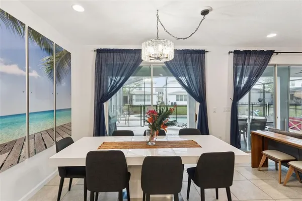 a kitchen with a dining table chairs and white cabinets