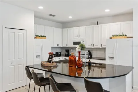 a kitchen with white cabinets and white appliances