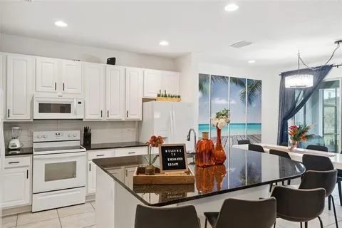 a kitchen with white cabinets and refrigerator