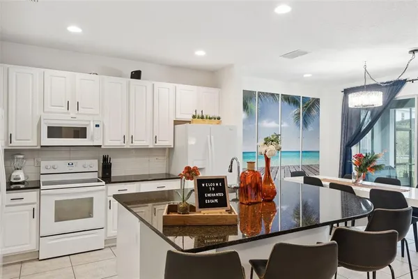 a kitchen with white cabinets and refrigerator