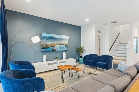 a living room with furniture and a wooden floor