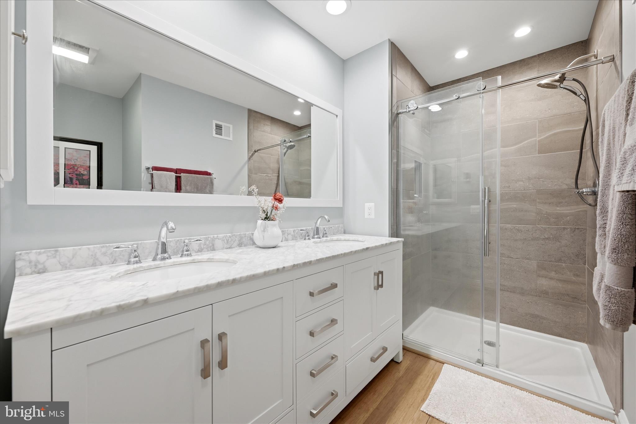 500 Delicious Road Linden, VA 22642 - Photo 21 of 80 a bathroom with a granite countertop sink a mirror a glass door and shower