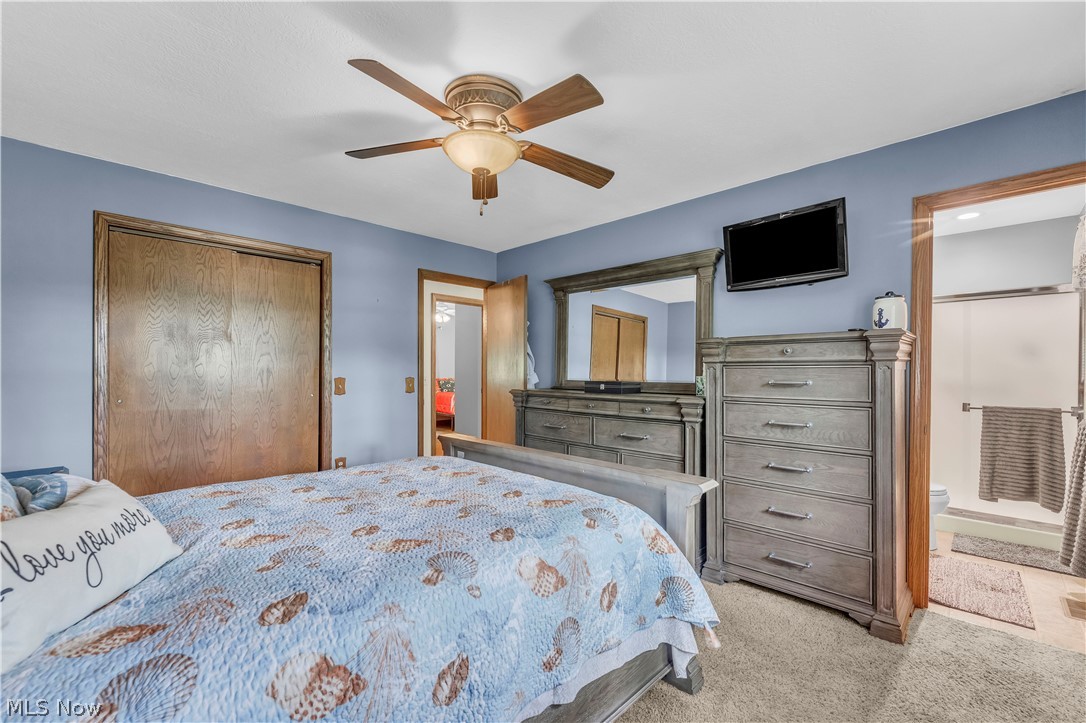 408 River Road Canal Fulton, OH 44614 - Photo 22 of 42 Bedroom with neutral wall-to-wall carpeting, a ceiling fan with integrated lighting, and a wood-finish sliding door closet