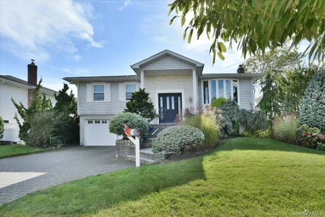 a front view of a house with a garden and plants
