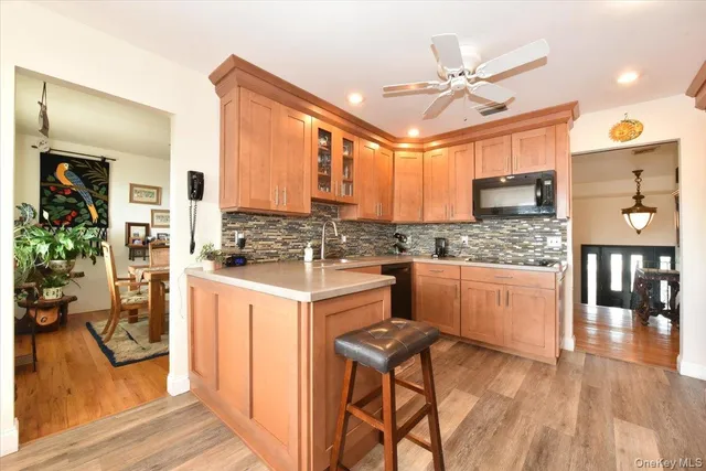 a kitchen with stainless steel appliances kitchen island granite countertop a stove refrigerator and cabinets