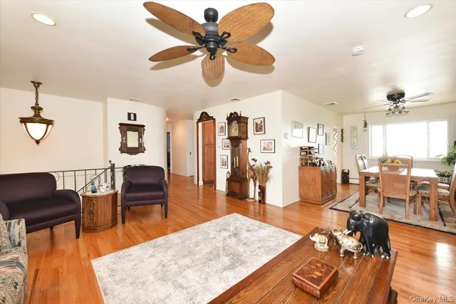 a living room with lots of furniture kitchen view and a large window