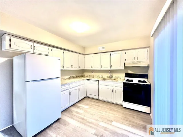 a kitchen with stainless steel appliances granite countertop a refrigerator and a stove