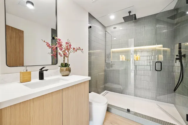 a bathroom with a sink a toilet and shower