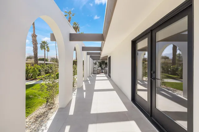 a hallway with a lot of flower plants in front of door