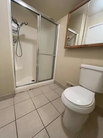 a bathroom with a toilet and a shower