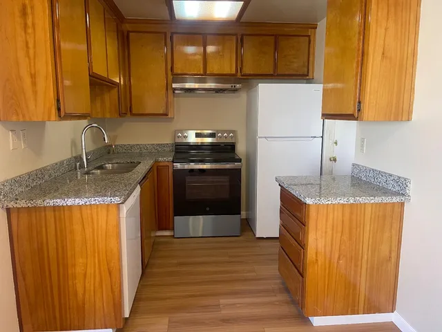 a kitchen with stainless steel appliances granite countertop a sink stove and refrigerator